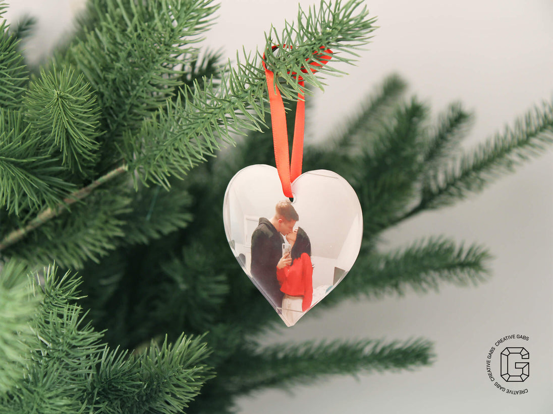 Herzförmige Acryl-Weihnachtskugel mit Foto – aufgehängt am Tannenbaum mit rotem Band