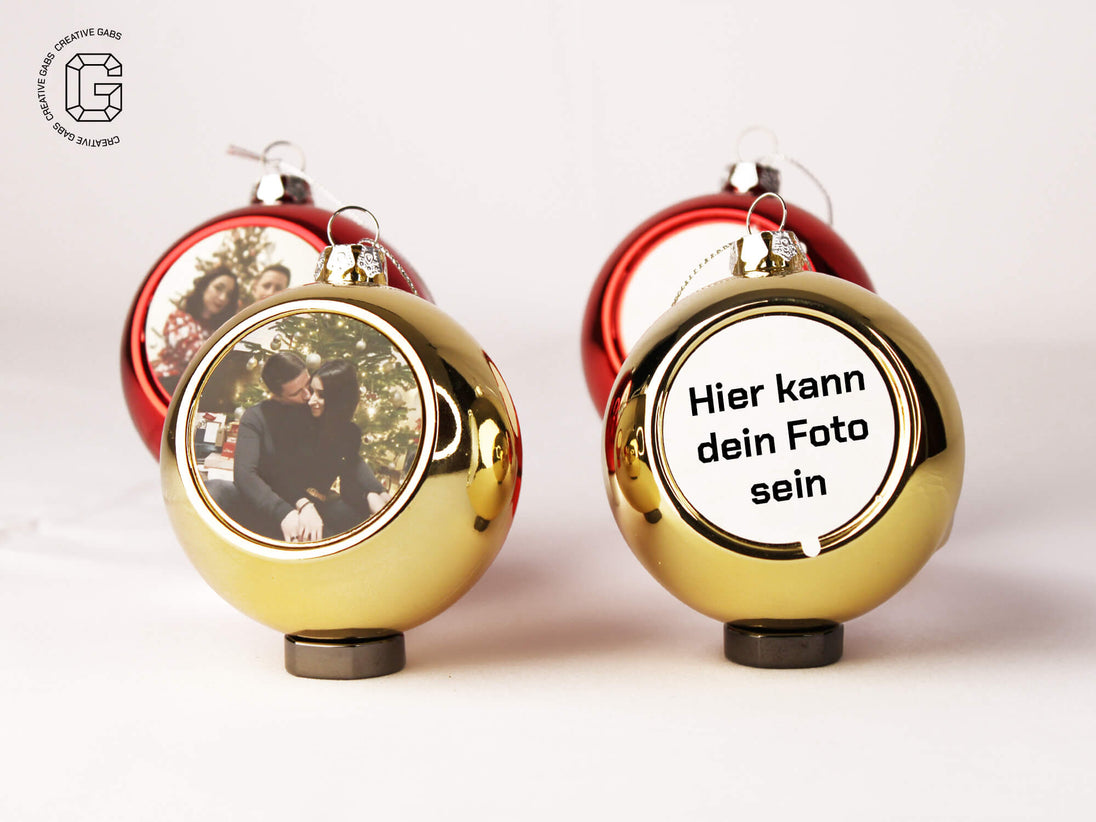 Set personalisierter goldener Weihnachtskugeln mit Foto – Vorderansicht auf weißem Hintergrund