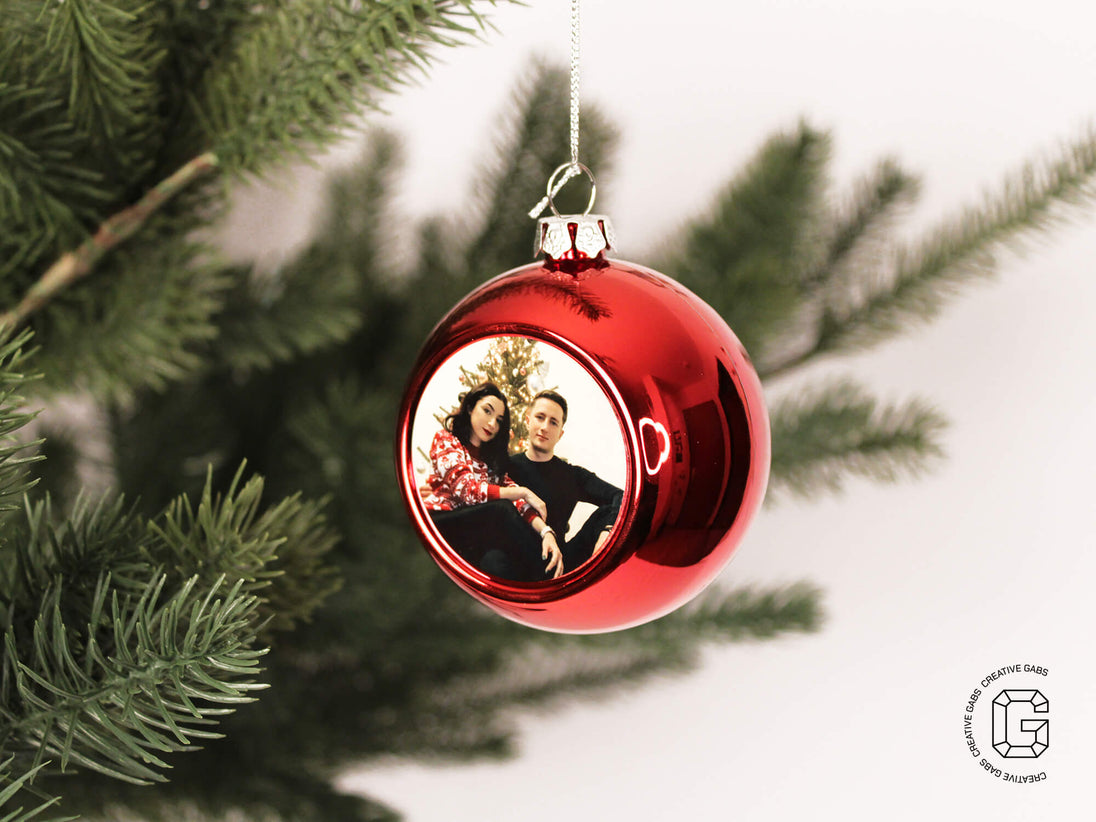 Rote personalisierte Christbaumkugel mit Foto im geschmückten Weihnachtsbaum