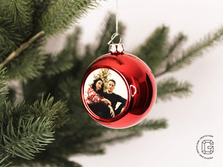 Rote personalisierte Christbaumkugel mit Foto im geschmückten Weihnachtsbaum